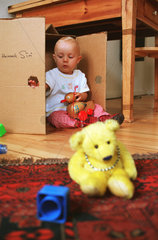 Kleinkind (11 Monate) spielt mit Pappkarton  Berlin