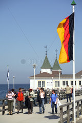 Ahlbeck  Touristen und Fahne vor der Seebruecke an der Ostsee