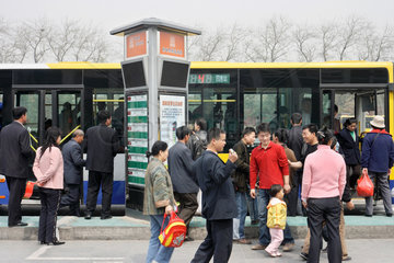 Peking  Fahrgaeste warten an der Bushaltestelle auf den Bus