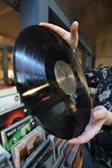 Flensburg  Deutschland  Plattenhaendler Andreas Thomsen mit einer Schallplatte aus Vinyl