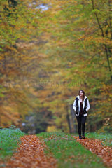 Schwarzenbek  Deutschland  eine junge Frau spaziert in einem herbstlichen Wald