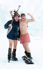 Krippenbrunn  Oesterreich  leichtbekleidete junge Maenner mit Snowboard und Skier
