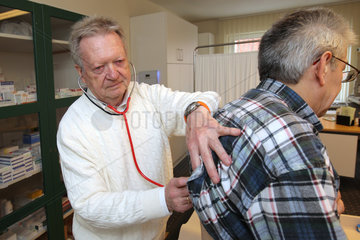 Bad Segeberg  Deutschland  Dr. Uwe Denker untersucht einen Patienten in seiner Praxis ohne Grenzen