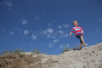 Hvide Sande  Daenemark  ein Junge springt von einer Duene