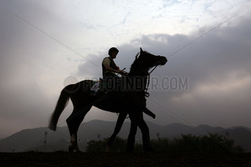 Hong Kong  Silhouette von Reiter und Pferd