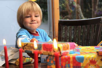 Harrislee  Deutschland  Junge packt zu seinem vierten Geburtstag Geschenke aus