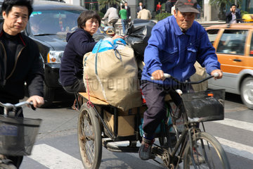Shanghai  alter Mann faehrt eine Rikscha