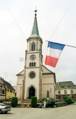 Kirche mit franzoesischer Flagge im Elsass