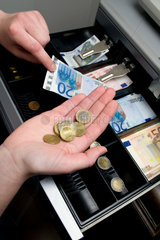 Berlin  Deutschland  eine Verkaeuferin zaehlt das Wechselgeld in einer Registrierkasse