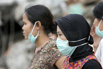 Padang  Indonesien  Frauen tragen bei Aufraeumarbeiten einen Mundschutz gegen den Staub