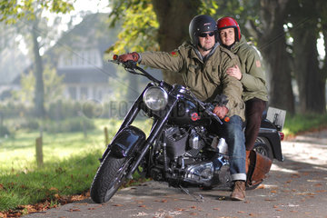Handewitt  Deutschland  ein Ehepaar sitzt auf seinem Motorrad  einer Harley-Davidson