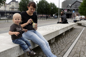 Berlin  Deutschland  eine Mutter und ihr Sohn sitzen auf einer Bank