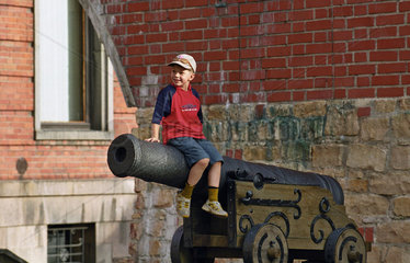 Ein Junge sitz auf einem Kanonenrohr  Riga  Lettland