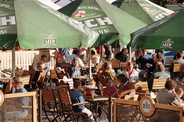 Menschen in einem Biergarten mit Werbung von -Lech-  Poznan  Polen