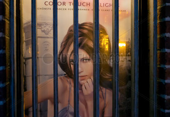 Berlin  Deutschland  Plakat in einem vergitterten Fenster eines Friseursalons
