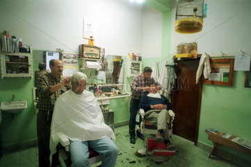 Teror  Gran Canaria  Spanien  Maennerfriseure beim Haareschneiden und Rasur