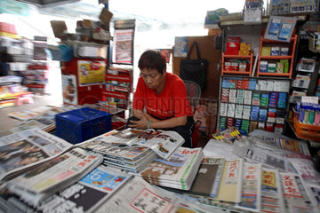 Hong Kong  Zeitungsverkaeufer liest eine Zeitung
