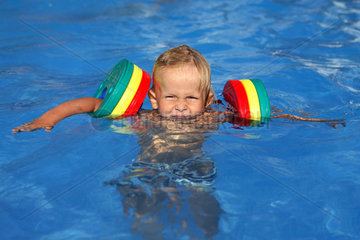 Cala d'Or  Kleinkind mit Schwimmfluegeln im Wasser