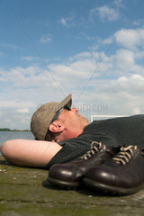 Krakow am See  Deutschland  ein Mann liegt auf einem Steg in der Sonne