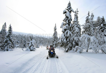 Saelen  Schweden  Maenner fahren auf Schneemobilen