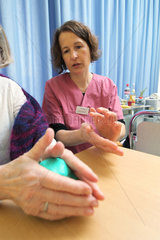Flensburg  Deutschland  Ergotherapeutin macht mit einer Patientin Uebungen mit Knetgummi