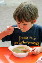 Halle  Deutschland  Junge isst Erbsensuppe mit Wuerstchen