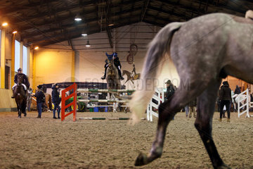 Neustadt (Dosse)  Pferde und Reiter im Winter auf einem Turnier in der Abreitehalle