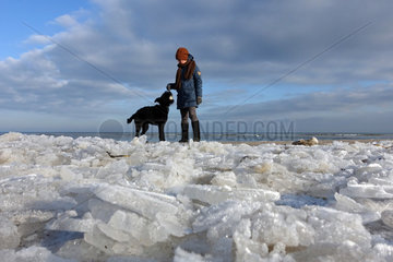 Ahlbeck  Deutschland  Frau spielt mit ihrem Hund im Winter am Strand