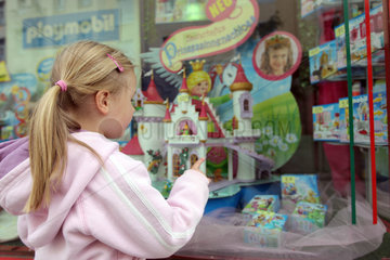 Flensburg  Deutschland  Maedchen steht vor einem dekorierten Schaufenster und schaut sich die Spielsachen an