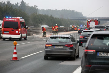 Allersberg  Deutschland  Feuerwehrmaenner beseitigen nach einem Autounfall auf der A9 eine Oelspur