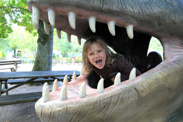 Tolk  Deutschland  Kind in einem rekonstruierten Dinosauriermaul im Freizeitpark Tolk-Schau