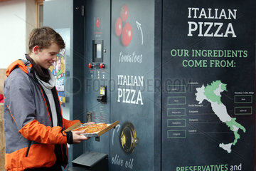 Reischach  Italien  Junge schaut stolz auf seine aus einem Automaten gezogene Pizza