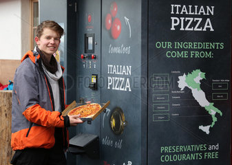 Reischach  Italien  Junge zeigt stolz seine aus einem Automaten gezogene Pizza