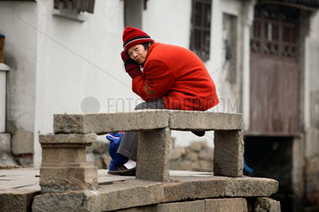 Suzhou  alter Mann sitzt auf einer Bank