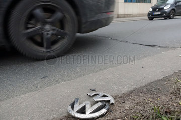 Berlin  Deutschland  zerbrochenes Kuehlergrill-Emblem eines Volkswagen liegt am Strassenrand