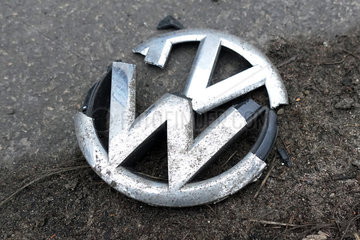 Berlin  Deutschland  zerbrochenes Kuehlergrill-Emblem eines Volkswagen liegt am Strassenrand