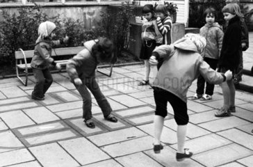 Berlin  DDR  Kinder in einer Kindertagesstaette bei einem Huepfspiel