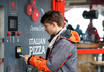 Reischach  Italien  Junge bedient einen Pizza-Automaten