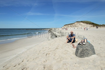 Hoernum  Deutschland  Besucher ruhen sich an Tetrapoden am Strand von Hoernum auf Sylt aus