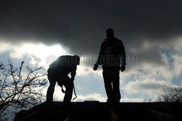 Berlin  Deutschland  Silhouette  Handwerker arbeiten auf dem Dach einer Gartenlaube