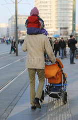 Berlin  Deutschland  Mann traegt sein Kind auf den Schultern und schiebt einen Kinderwagen