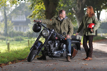 Handewitt  Deutschland  ein Ehepaar steht neben seinem Motorrad  Harley-Davidson