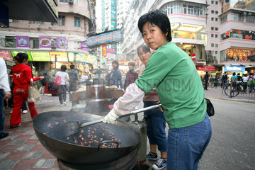 Hong Kong  Frauen bei der Zubereitung von Maronen in einem Wok in der Stadt