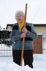 Nauen  Deutschland  eine alte Frau leistet Winterdienst