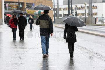 Potsdam  Deutschland  Passanten bei Regenwetter mit Schirm