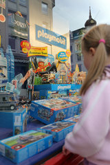 Flensburg  Deutschland  Maedchen steht vor einem dekorierten Schaufenster und schaut sich die Spielsachen an