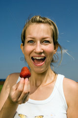 Junge Frau isst eine Erdbeere  Berlin
