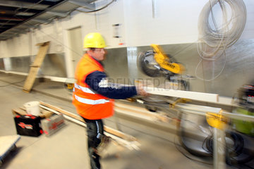 Schoenefeld  Deutschland  Bauarbeiter arbeitet an einer Saege auf der BBI Baustelle