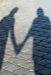 Schatten zweier Menschen  die sich an den Haenden halten