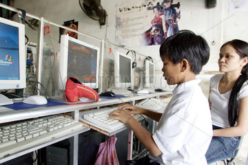 Vietnam  Junge surft und spielt in einem Internetcafe